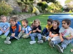 Niños sentados en las áreas verdes del jardín